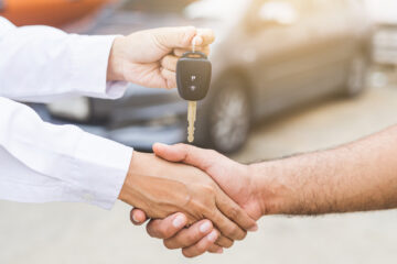 Grafika główna przedstawiająca zawarcie umowy kupna samochodu używanego ilustrująca artykuł:"Dlaczego warto sprawdzić historię używanego samochodu przed zakupem?"